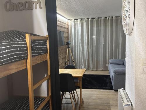 Cette petite chambre comprend des lits superposés et un bureau. dans l'établissement Studio aux Gets avec Wi-Fi, parking et animaux admis - FR-1-671-294, aux Gets
