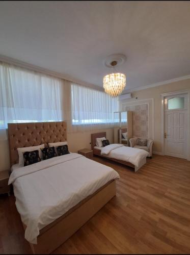a large bedroom with two beds and a chandelier at Holiday inn Adnan boutique hotel and pool in Gabala