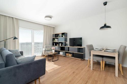 ポズナンにあるBright Apartment Bulgarska with Parking near ENEA Stadium by Noclegi Rentersのソファとテーブルのあるリビングルーム