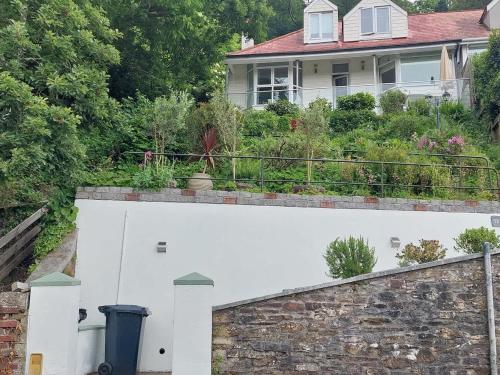 a house with a garden on top of a wall at Cosy Home on the Waterfront Private Parking in Looe