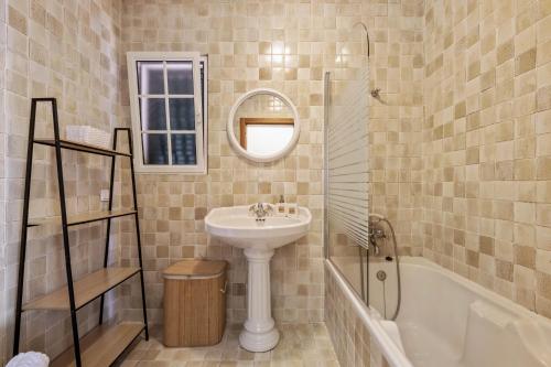 a bathroom with a sink and a mirror and a tub at Amendoeira Residence by Homie in Quinta do Almeida