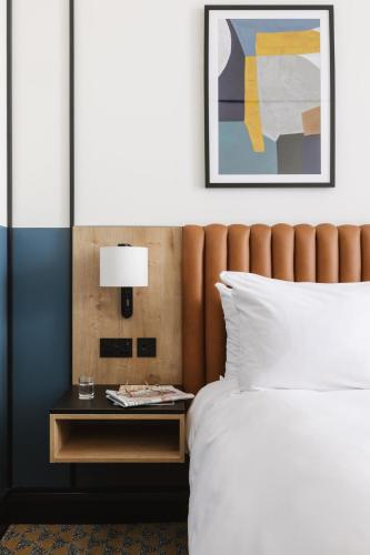 a bedroom with a bed and a table with a lamp at voco Belfast by IHG in Belfast