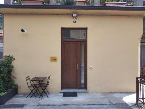 a wooden door with a table and chairs on a building at La CasaLina in Omegna