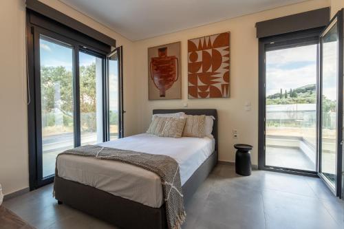 a bedroom with a bed and large glass windows at Eros sea view residences Mytilini in Agia Marina Lesvos