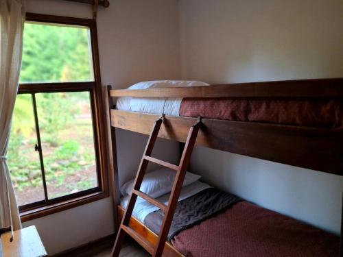 a bunk bed room with two bunk beds and a ladder at Cabanas Mapulauquen in Pucará