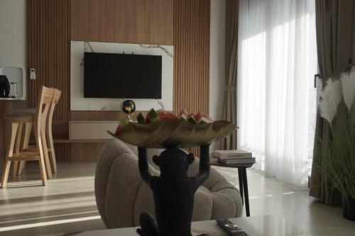 a person holding a plate of fruit in a living room at Vienna Luxury Apartments in Dobra Voda