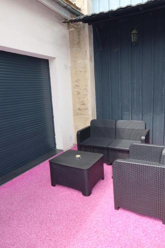 ein Raum mit zwei Stühlen und Tischen und rosa Teppich in der Unterkunft SPA PRIVATIF - LOVE ROOM LUXE - PROCHE DISNEY in Marles-en-Brie