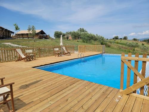 a swimming pool on a wooden deck with a wooden fence at Glamping Tenuta Radici in Castelnuovo della Misericordia