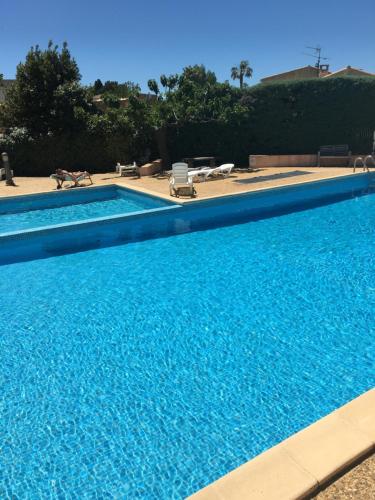une grande piscine avec de l'eau bleue dans l'établissement Bandol appartement classé 2 étoiles, à La Celle-sous-Gouzon