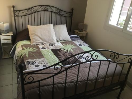 - une chambre avec un lit avec un cadre métallique dans l'établissement Bandol appartement classé 2 étoiles, à La Celle-sous-Gouzon