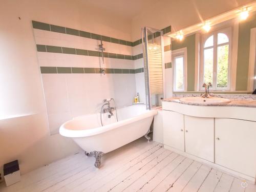 une salle de bain blanche avec une baignoire et un lavabo dans l'établissement Les Trois Moulins - 10min de Pont L'Evêque - 6 personnes, à Les Authieux-sur-Calonne