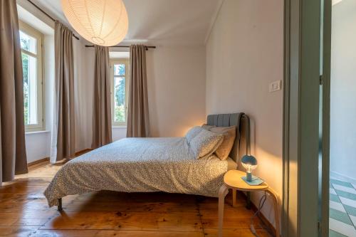 a bedroom with a bed and a table with a lamp at Villa Le Camelie - Charme & Relax in Pinerolo