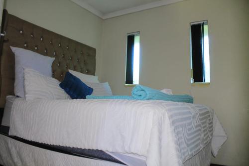 a bedroom with a large bed with white sheets and pillows at 26 Zea avenue Arcon Park Guest House in Vereeniging