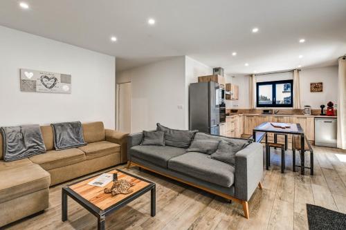 un salon avec un canapé et une cuisine dans l'établissement Aux pieds des pistes - Appt B, à Ax-les-Thermes
