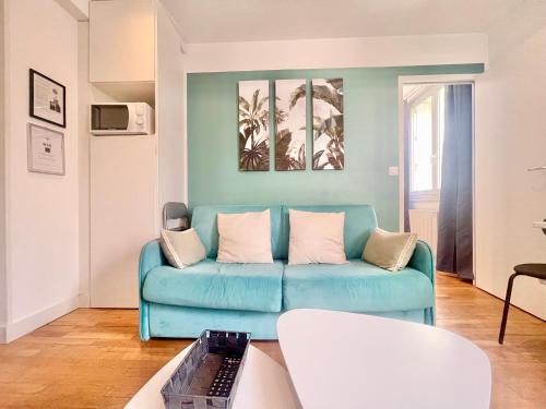 un salon avec un canapé bleu et une table dans l'établissement APPARTEMENTS 