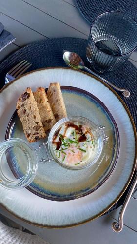 a plate of food with bread and a bowl of soup at Le Clos 1855 in Saint-Laurent-des-Bâtons