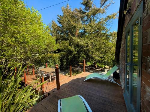 a deck with two chairs and a table on it at Sunridge Fishing Lodge with Hot Tub & Giant Cinema in Plymouth