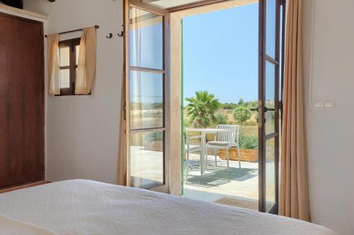 a bedroom with a bed and a sliding glass door at Agroturismo Finca Son Valls - Adults Only in Felanitx