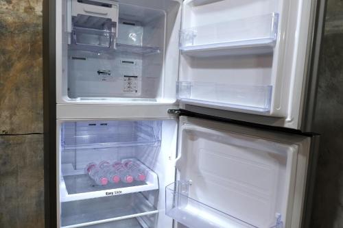 an open refrigerator with its door open and some food inside at City House Don Mueang Airport Bangkok in Don Muang Airport