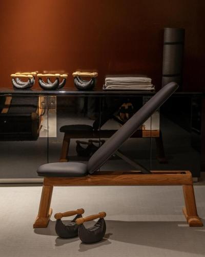 une table avec un banc et des chaussures sur le sol dans l'établissement Hôtel Château d'Eau, à Paris