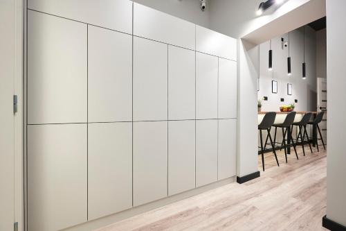タリンにあるBOLD Stay - New Self Check-In Hostel in City Centerのテーブルのある部屋の白いキャビネットの壁