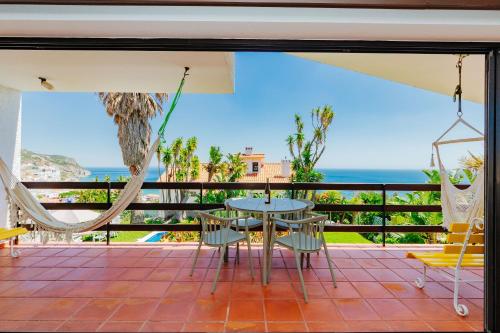 a patio with a table and chairs and the ocean at Panoramic Ocean View Villa & Pool in Sesimbra by Rent4Rest in Sesimbra