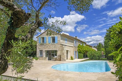 an exterior view of a house with a swimming pool at Mas du Micocoulier in Paradou