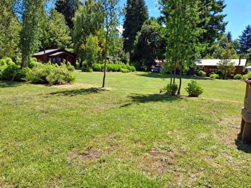 a park with a field of grass and trees at Cabanas Mapulauquen in Pucará