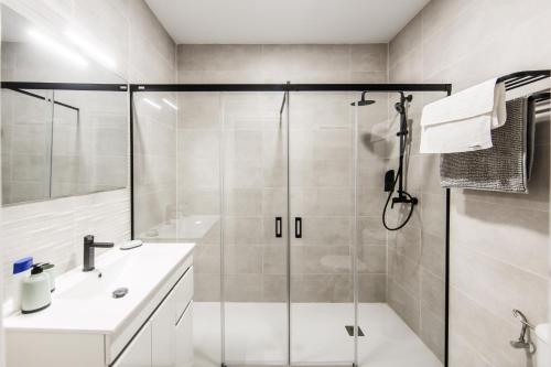 a bathroom with a glass shower and a sink at Apartamentos LUXURY SUITES MERLOT in Almendralejo