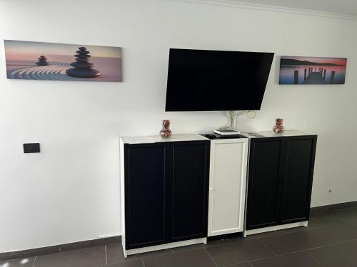 a room with two black cabinets and a flat screen tv at Casa Rica in Puerto Rico de Gran Canaria