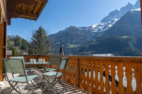 a table and chairs on a balcony with mountains at La Tour d'Anthème 3 chambres 8 personnes in Champéry