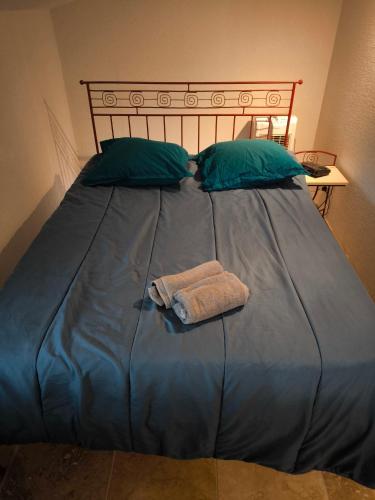 - un grand lit bleu avec une serviette dans l'établissement Chez Philipe Jasse 548, à Gallargues-le-Montueux