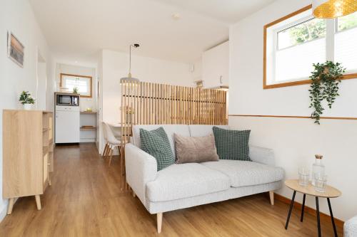a living room with a couch and a kitchen at Die Böttgerei Dünenkeiler in Dahme