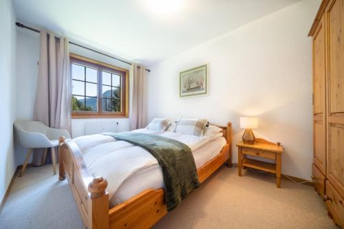 a bedroom with a wooden bed and a window at La Tour d'Anthème 3 chambres 8 personnes in Champéry