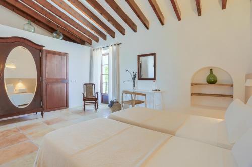 a white bedroom with a bed and a table at Agroturismo Finca Son Valls - Adults Only in Felanitx