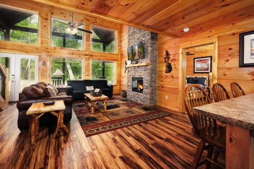 a living room with a fireplace in a log cabin at 2BR, slps 10, 8 min to Dollywood, hot tub! in Pigeon Forge