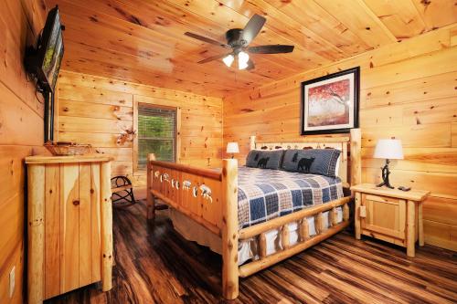 a bedroom with a bed in a log cabin at 2BR, slps 10, 8 min to Dollywood, hot tub! in Pigeon Forge