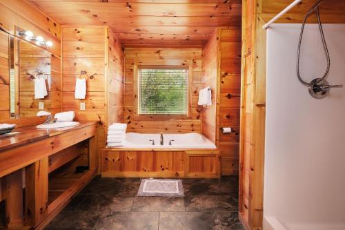 a wooden bathroom with a tub and a window at 2BR, slps 10, 8 min to Dollywood, hot tub! in Pigeon Forge