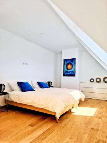 une chambre avec un lit et un tableau au mur dans l'établissement Le petit Alice cottage, à Cléder