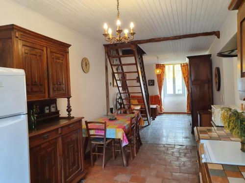 - une cuisine avec une table et une échelle dans une pièce dans l'établissement Gite Le jardin de Céline, à Saint-Gervais-sur-Mare