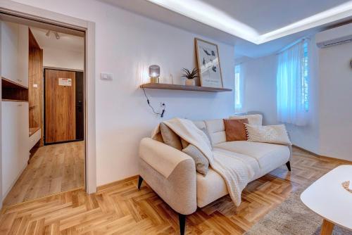 una sala de estar con un sofá y una mesa en Marasca Belgrade - Cozy, Chic & Nomad-friendly Flat in Downtown, en Belgrado