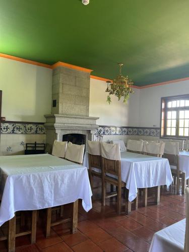 a dining room with white tables and a fireplace at Casa Augusta - QUINTA in Penafiel