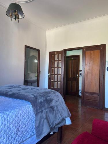 a bedroom with a bed with a blue comforter at Casa Augusta - QUINTA in Penafiel