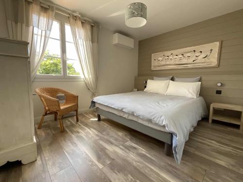 une chambre avec un lit, une chaise et une fenêtre dans l'établissement Family Fun, Beach, Biking and Relaxation, à La Couarde-sur-Mer
