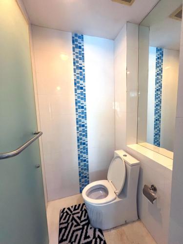 a small bathroom with a toilet and a shower at Beachfront Luxe with Pool Access and Terrace in Pattaya North