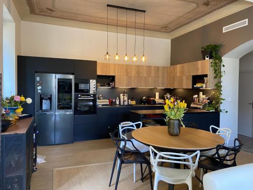 une cuisine avec une table en bois et des armoires bleues dans l'établissement Chambre Vue Jardin Alsace Lorraine Victor Hugo, à Nice