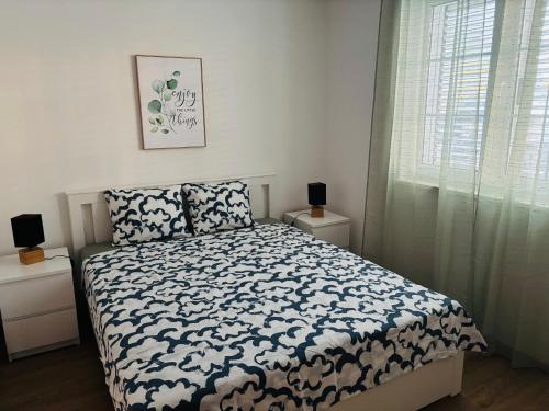 a bedroom with a bed with a black and white comforter at Apartmani Summer in Kolan