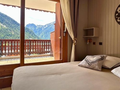 une chambre avec un lit et une grande fenêtre dans l'établissement Le Levasset vue montagne proche pistes, à Champagny-en-Vanoise