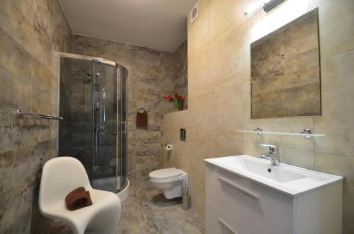 a bathroom with a toilet and a sink and a shower at Pensjonat Sunrise in Rewal