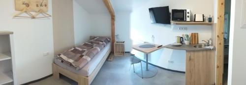 a small room with a bed and a desk in it at Landcafe SIMA & Zimmervermietung in Forheim